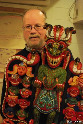 Associate Professor and Chair of Creative Arts Therapies Stephen Snow stands with the Sanni Yakka mask he had commissioned during his recent trip to Sri Lanka.